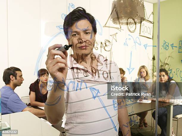 Office Manager Writing Information On Glass Wall Stock Photo - Download Image Now - People, Portrait, Writing - Activity