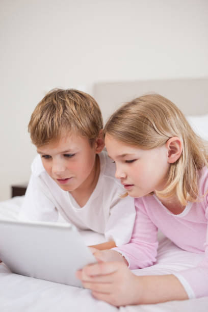 istock Portrait of cute children using a tablet computer 828212916