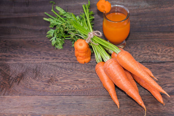 istock Fresh carrot  on a grey wooden table wall background with copy space . 828226710