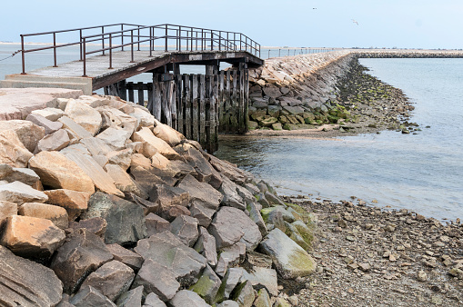 Gap in the breakwater at Plymouth, Massachusetts enables small boats to take a shortcut to leave the harbor when tides are higher