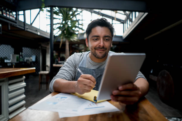 istock Man working at a restaurant doing the books 828241360