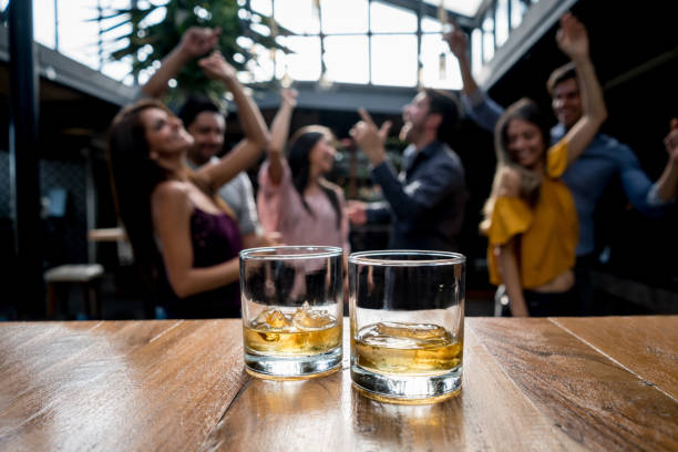 Group of friends having drinks at a bar Group of friends having drinks at a bar and having fun - focus on foreground Shot of Whiskey stock pictures, royalty-free photos & images