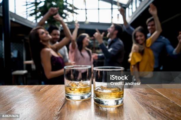 Group Of Friends Having Drinks At A Bar Stock Photo - Download Image Now - Whiskey, Drinking, Friendship