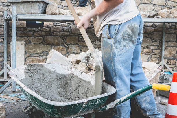 istock man makes concrete in a wheelbarrow on a renovation site 828241726