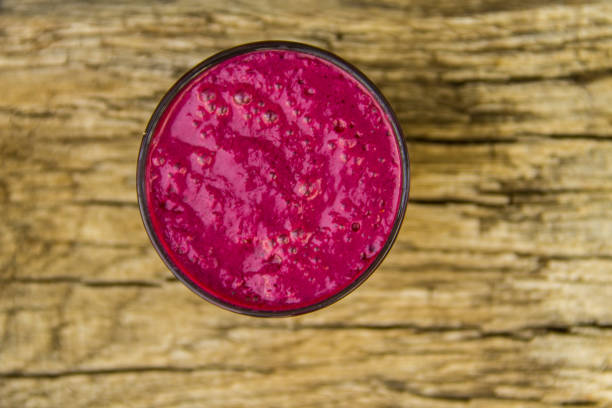 istock Glass of berry smoothie on rustic wooden table 828249042