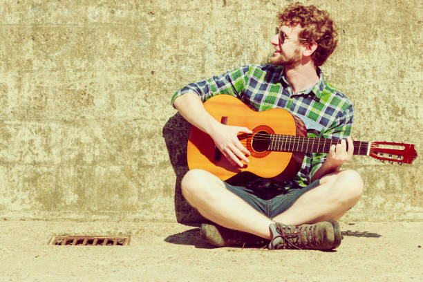 istock Young bearded hipster man with guitar outdoor 828249900