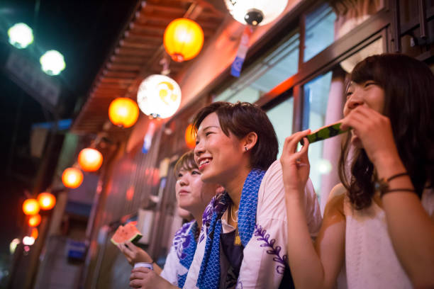スイカを食べた地元の祭りのパフォーマンスを見て若い女性 - 日本　祭り ストックフォトと画像
