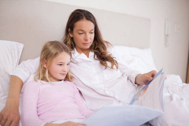 istock Girl reading a book with her mother 828283262