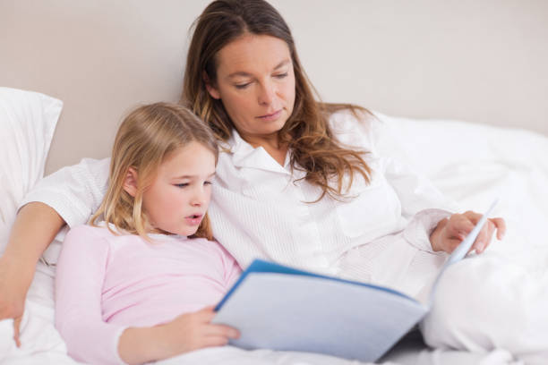 istock Cute girl reading a book with her mother 828283356