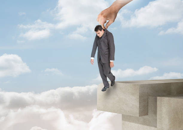 istock Giant hand dropping off a businessman over the clouds 828305640