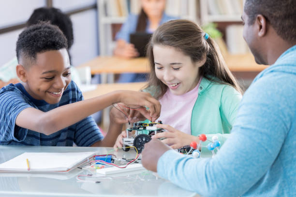 istock Two preteen students connect wiring on robotics project at school 828329706