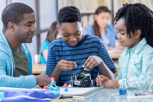 istock Preteen student completes wiring on robotics project 828329712