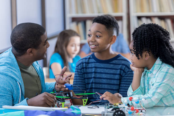 istock Preteen student discusses robotics project with father 828329724