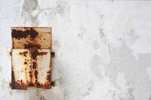 istock Rusty neglected vintage metal post box attached on wall with deterioration. 828349862