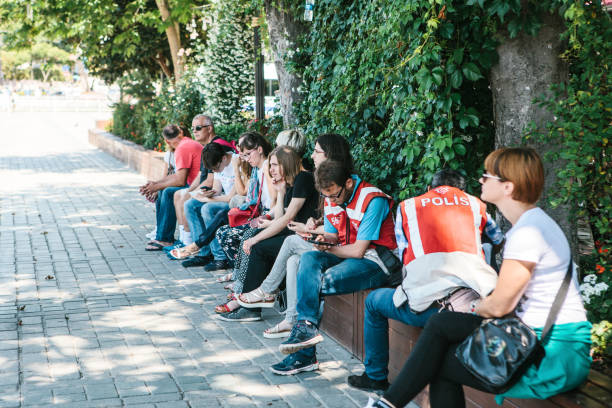 istanbul, 16 juin 2017 : deux turcs turism policiers à sultanahmet square, avec groupe de gens assis à proximité. - vine photos et images de collection