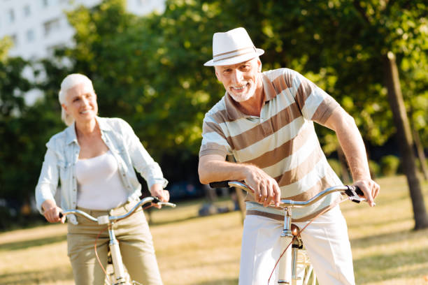 istock Positive elderly people riding bicycles in park 828372820