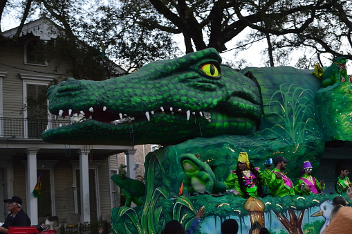 New Orleans, LA - February 8, 2015: Marching bands, dancers, and Mardi Gras floats entertain the crowds during Carnival Season.  People gather on each side of the street to watch the elaborately decorated floats and costumed marchers in the parades.  Each Mardi Gras float is decorated to a theme for the parade.