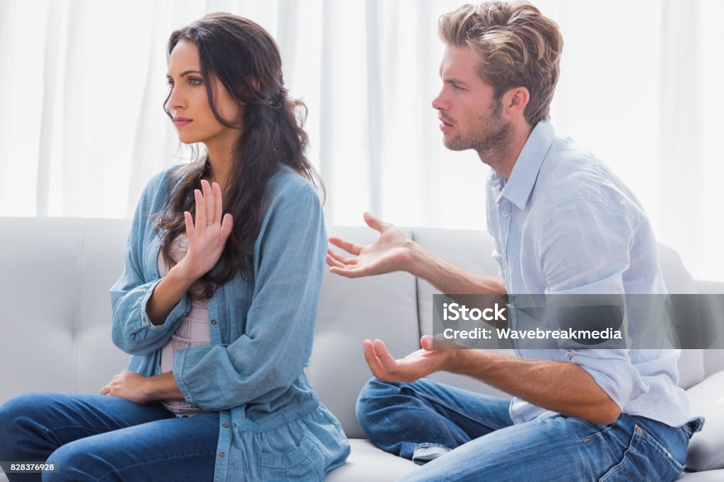 Woman gesturing while quarreling with her partner Woman gesturing while quarreling with her partner in the living room 20-24 Years Stock Photo