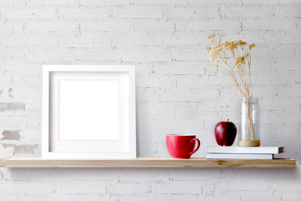 Wood shelf with blank white frame and coffee.