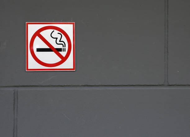 istock No smoking sign on the grey brick wall. 828406706