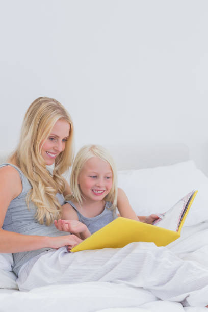 istock Cheerful mother and daughter reading a story together 828411996