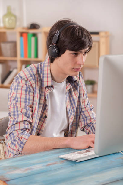 istock Teenager at the desk is programing and doing homework 828418840