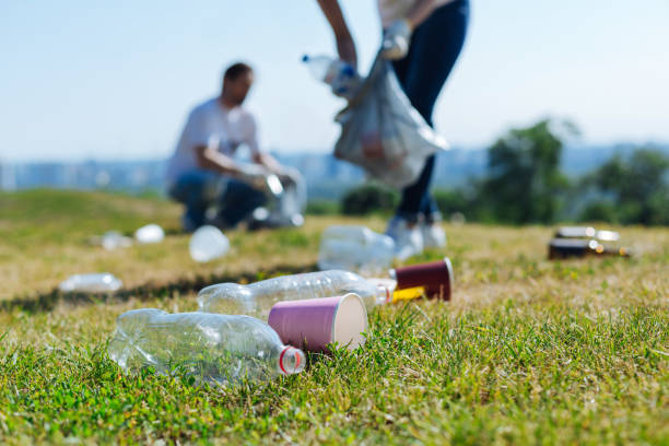 istock Devoted energetic people collecting litter on a grass 828418970