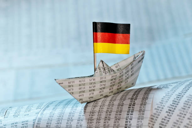 Paper ship with German flag on newspaper pages with course tables.