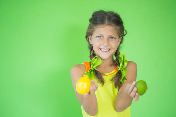 istock Smiling girl holding lemon and lime in her hands 828424388