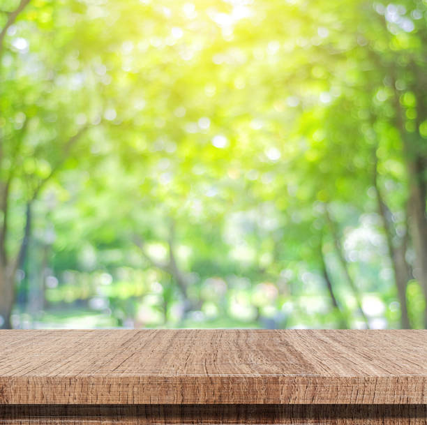 istock Empty wooden table over blurred tree with bokeh background, for product display montage 828428832