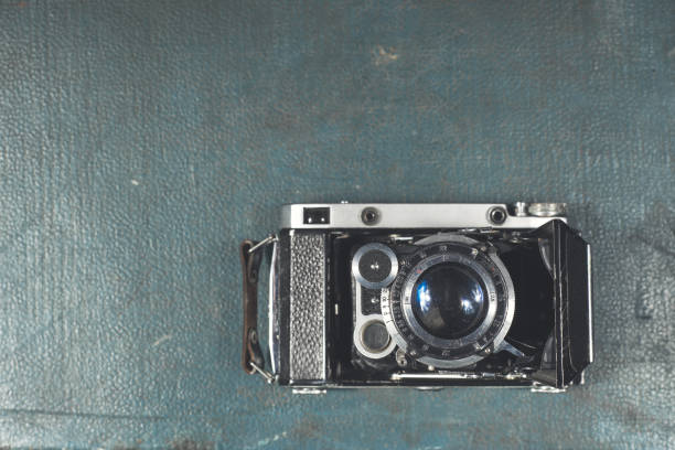 stará vintage kamera na modrém poškrábaném pozadí. zaostřete na objektiv - jednorázovým fotky - stock snímky, obrázky a fotky