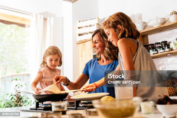 Hermanitas De Cocina Con Su Madre En La Cocina Foto de stock y más banco de imágenes de Crep francés - Crep francés, Familia, Cocinar