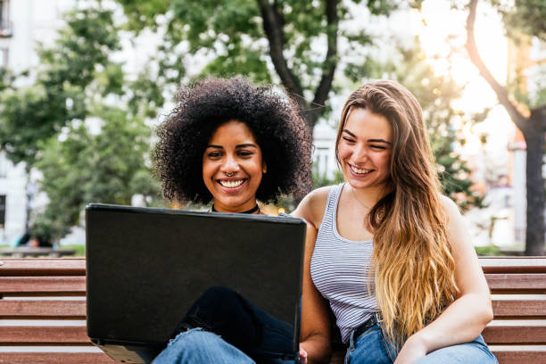 istock Beautiful women using a laptop in the Street. 828433366