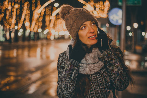 istock Beautiful young woman using phone by night 828435974