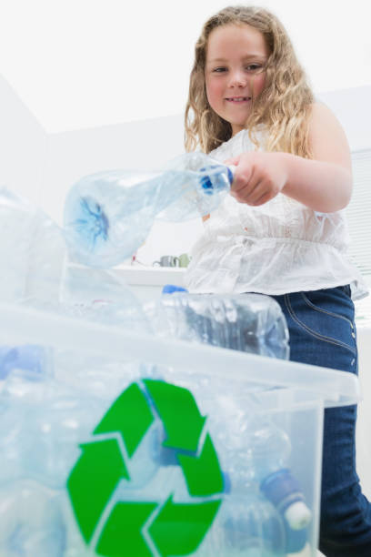 istock Girl throwing bottles into recycling box 828436854