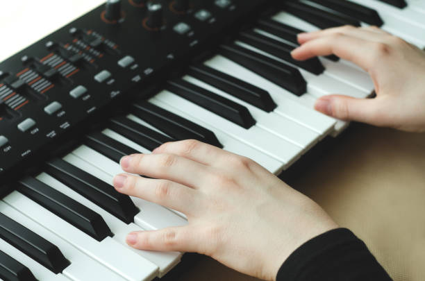 istock woman in a black jacket plays a synthesizer 828436902