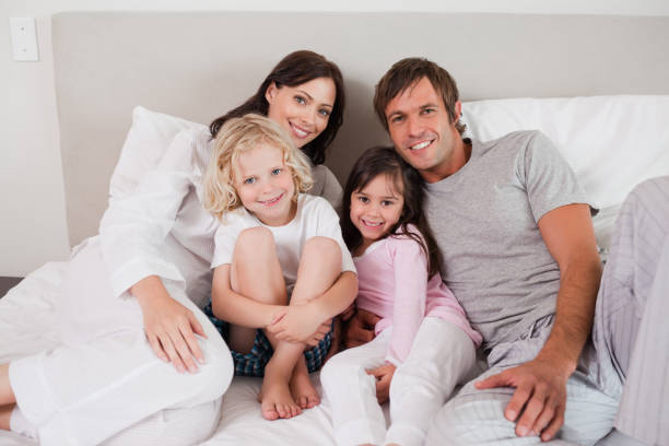 istock Smiling family posing on a bed 828437624