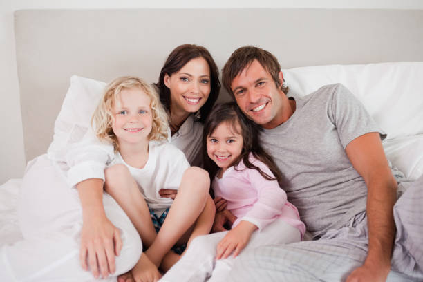 istock Happy family posing on a bed 828437672