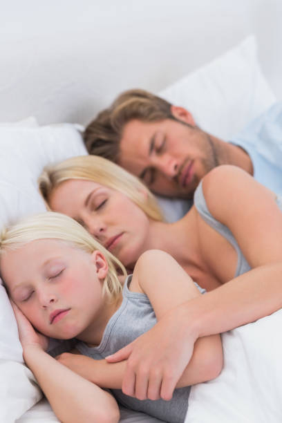 istock Couple sleeping with daughter 828437884