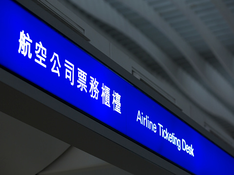 The signs for Airline ticketing at the hong kong international airport in Chinese characters and in English