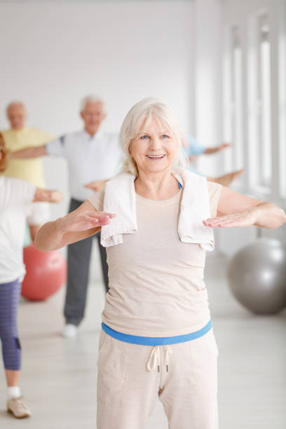 ältere dame in der turnhalle - senior adult sport yoga exercising stock-fotos und bilder