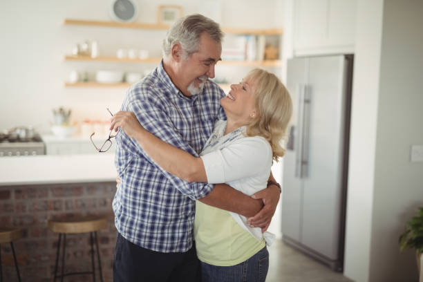 istock Smiling senior couple embracing each other in kitchen 828448144