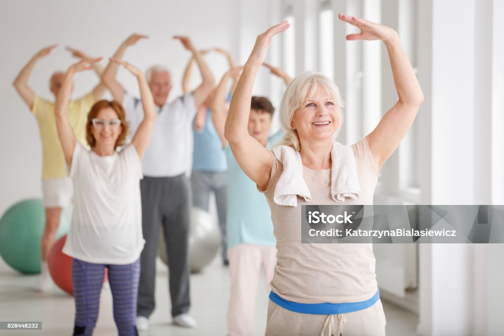 Seniors during warm up Group of happy seniors during warm up before exercise Senior Adult Stock Photo