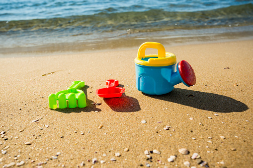 Children's beach toys with sea, long exposure photo