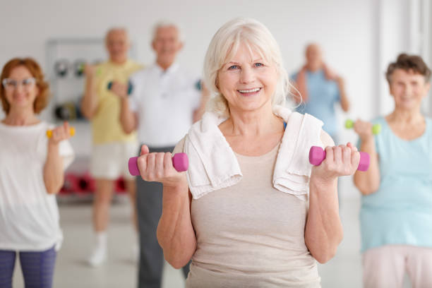 Elders with dumbbells Active happy elders with colorful dumbbells during training exercise class stock pictures, royalty-free photos & images