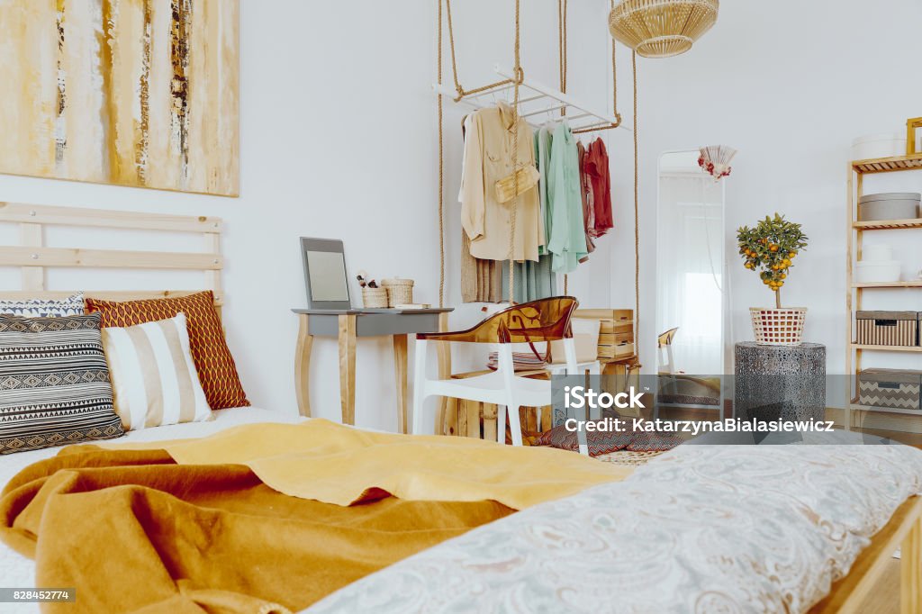 Bed with pillows and blanket Wooden king-size bed with decorative pillows and blanket in sandy colours Apartment Stock Photo