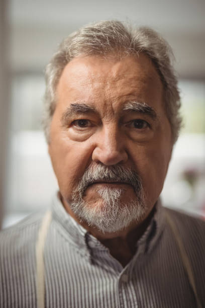 istock Confident senior man standing in home 828452832