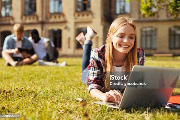 Young Optimistic Woman Checking Her Updates Stock Photo - Download Image Now - University, Lifestyles, Campus