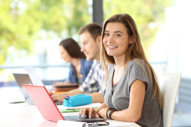 happy student posing in a classroom - college student high school student education learning imagens e fotografias de stock