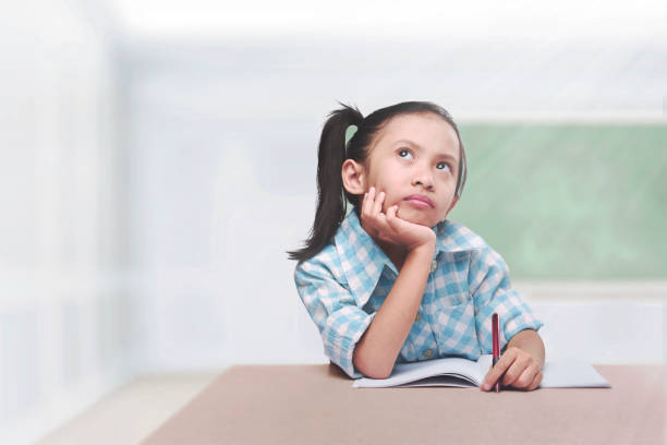 istock Cute asian child with book and pen learning 828458020